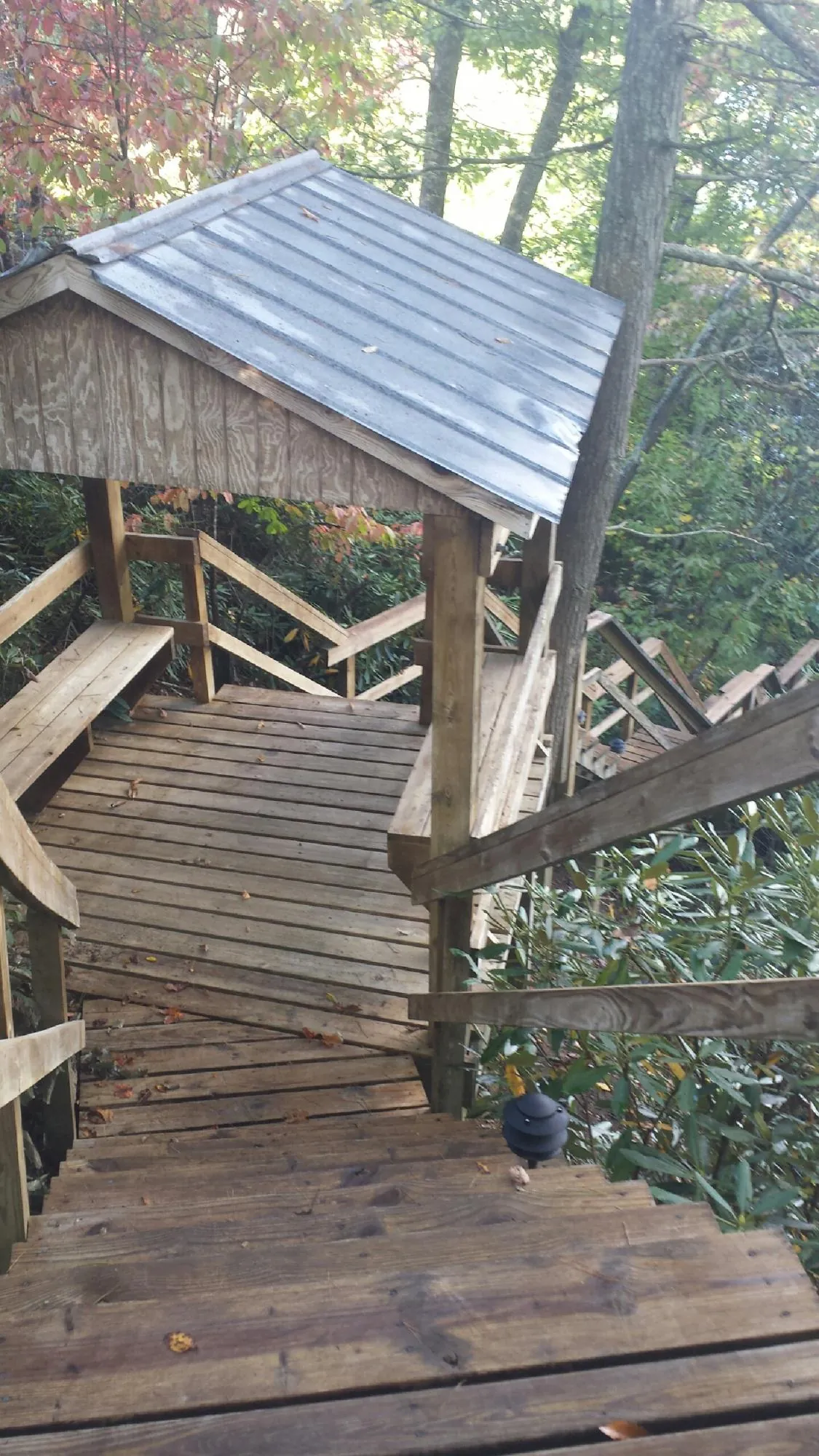 Metal roofed shelter over wooden steps on a wooded walkway — Skylight Repair & Installation work by our crew in Cleveland
